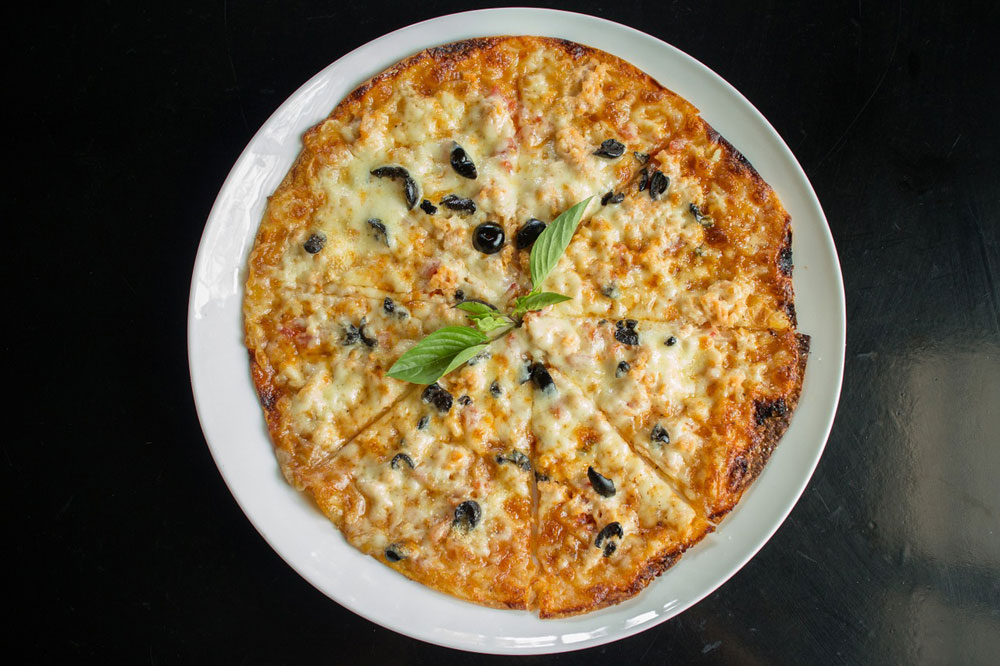 Pizza artisanale garnie d'olives et de légumes